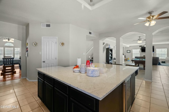 kitchen with light stone counters, visible vents, and a center island