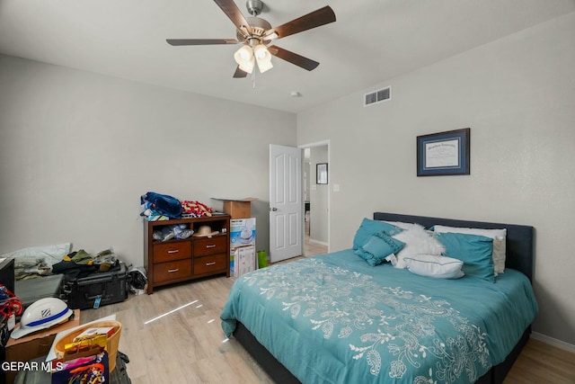 bedroom featuring light wood-type flooring, baseboards, visible vents, and a ceiling fan