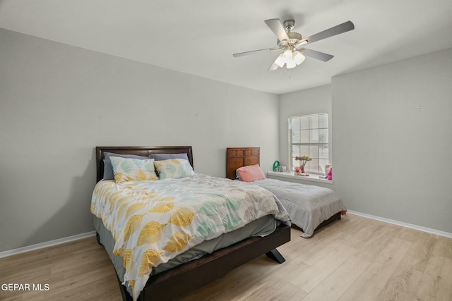 bedroom with baseboards, ceiling fan, and light wood finished floors