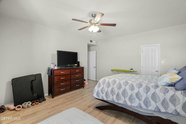 bedroom featuring light wood-style floors, visible vents, ceiling fan, and baseboards