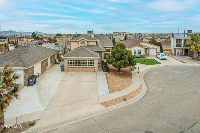 view of front facade with driveway, a residential view, a mountain view, and brick siding