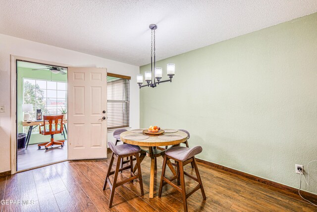 dining room with an inviting chandelier, baseboards, dark wood finished floors, and a textured ceiling