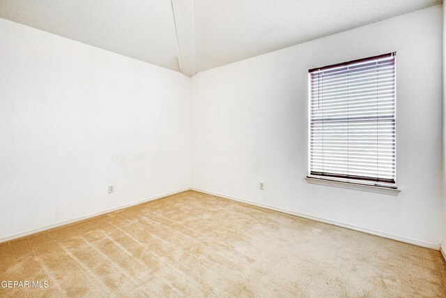 unfurnished room featuring a textured ceiling, carpet, and baseboards