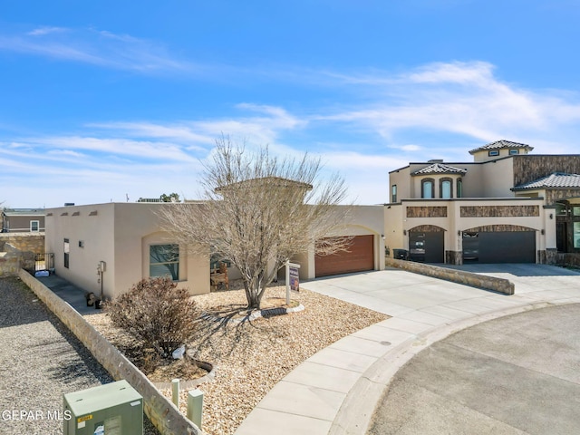 view of front of house with driveway, an attached garage, and stucco siding