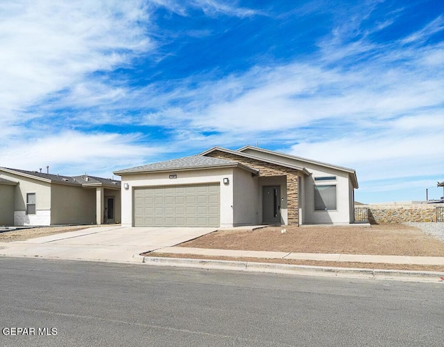 view of front of house featuring driveway, an attached garage, and stucco siding