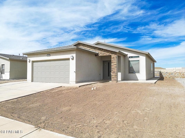 view of front of property featuring concrete driveway, stone siding, an attached garage, and stucco siding