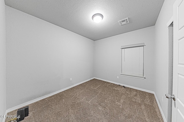 unfurnished room featuring a textured ceiling, carpet floors, visible vents, and baseboards