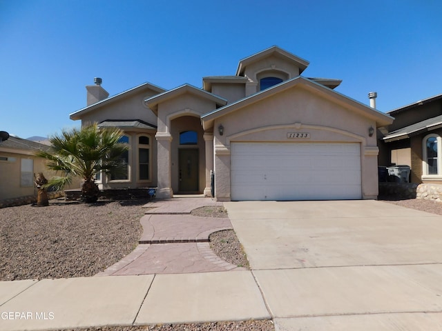 view of front facade featuring a garage, concrete driveway, a chimney, and stucco siding