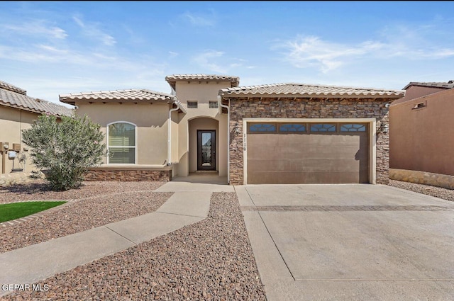 mediterranean / spanish-style home featuring an attached garage, stone siding, driveway, and stucco siding