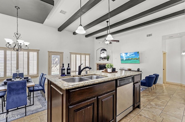 kitchen with a fireplace, visible vents, stainless steel dishwasher, open floor plan, and a sink