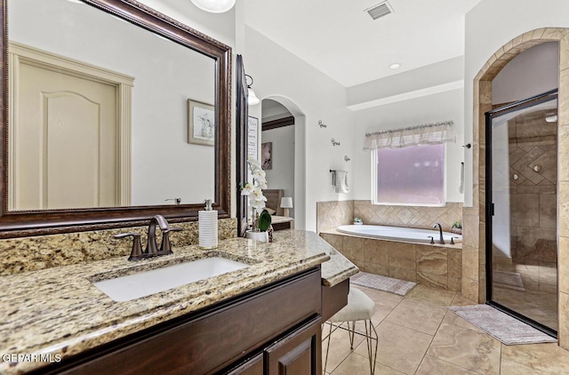 full bathroom with vanity, visible vents, a bath, and tiled shower