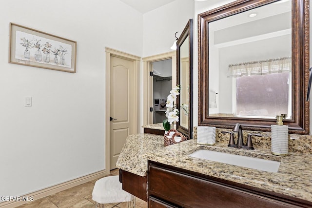 bathroom with baseboards, vanity, and tile patterned floors