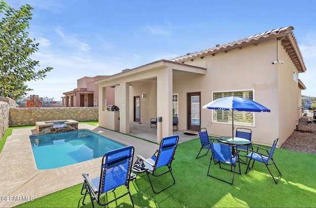 view of swimming pool featuring a yard, a pool with connected hot tub, a fenced backyard, and a patio