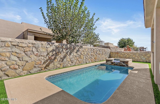 view of pool with a fenced backyard and a pool with connected hot tub