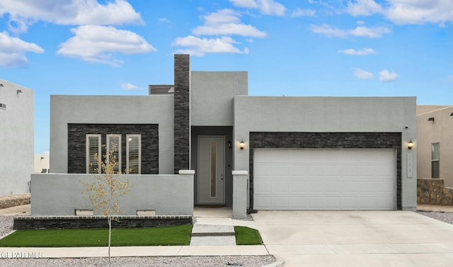 modern home with a garage, driveway, and stucco siding