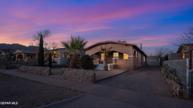 view of front of home featuring a fenced front yard, concrete driveway, and stucco siding