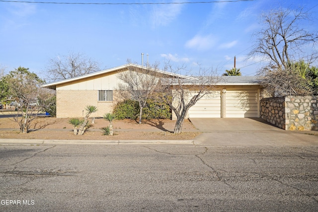 view of front of property with a garage, concrete driveway, and brick siding