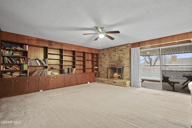 unfurnished living room with light carpet, a textured ceiling, and wooden walls