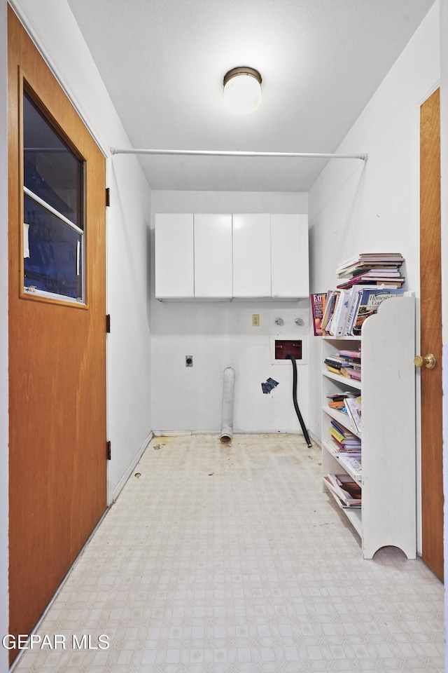 washroom featuring cabinet space, hookup for a gas dryer, light floors, and electric dryer hookup