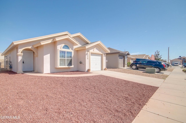 single story home featuring a garage, concrete driveway, and stucco siding