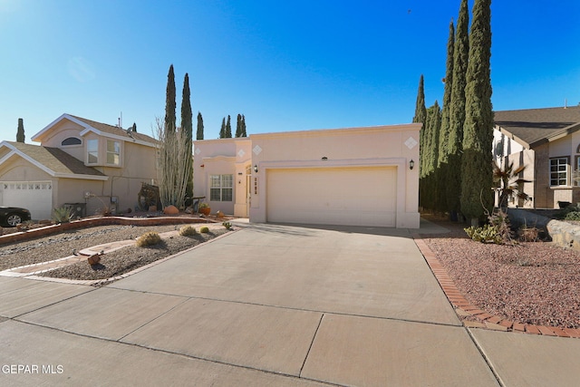 view of front of home featuring driveway, an attached garage, and stucco siding