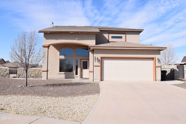 prairie-style house with driveway, an attached garage, fence, and stucco siding