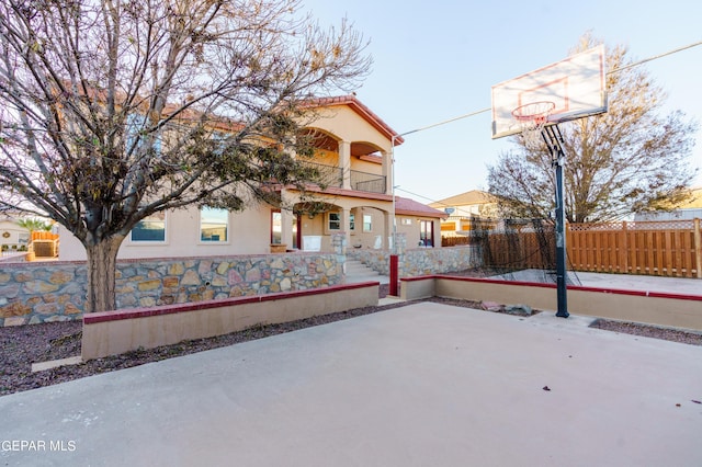 view of basketball court with a fenced front yard and basketball court