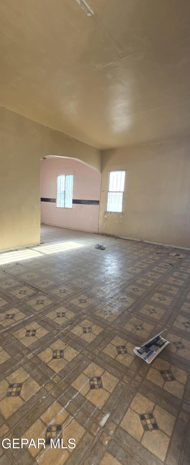 spare room featuring arched walkways