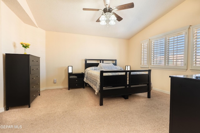 bedroom with baseboards, vaulted ceiling, and light colored carpet