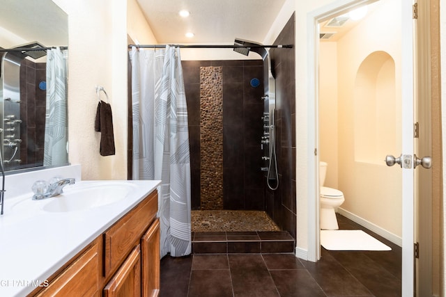 full bath featuring a stall shower, vanity, toilet, and tile patterned floors