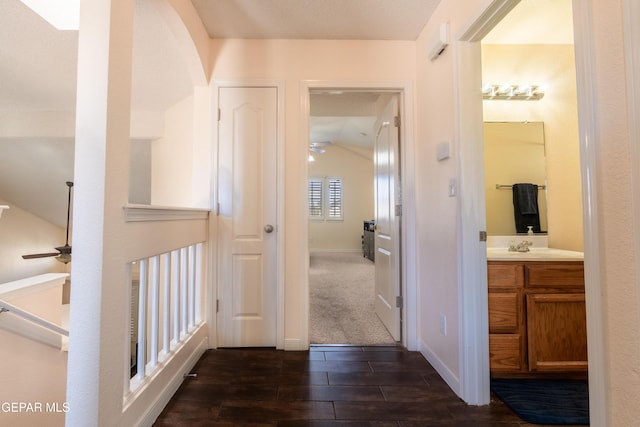 corridor with dark wood finished floors and baseboards