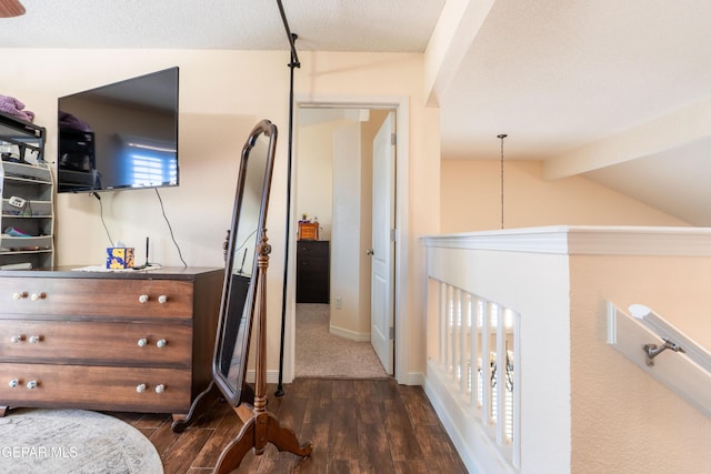 interior space with lofted ceiling with beams, baseboards, and dark wood-style flooring