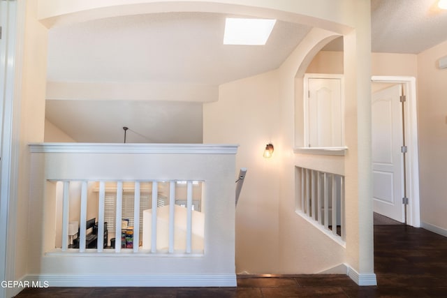 hallway featuring dark wood-style flooring and baseboards