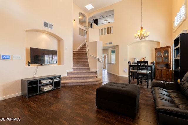 living room featuring dark wood-style floors, stairway, visible vents, and a notable chandelier