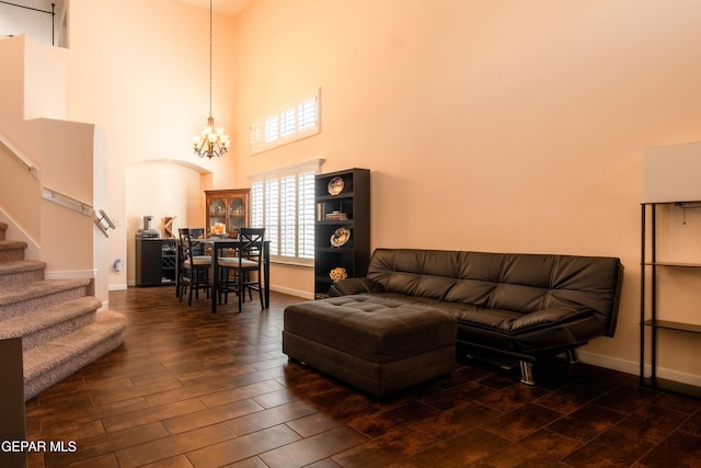 living room featuring stairs, baseboards, dark wood-style floors, and a notable chandelier