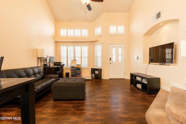 living room featuring dark wood-style floors, visible vents, baseboards, and high vaulted ceiling