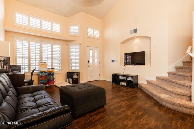 living area with dark wood-style floors, stairway, and visible vents