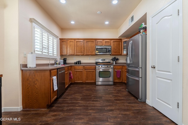 kitchen featuring recessed lighting, visible vents, appliances with stainless steel finishes, dark wood-style floors, and brown cabinetry