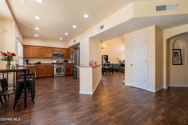 kitchen featuring dark wood-style floors, stainless steel appliances, and visible vents