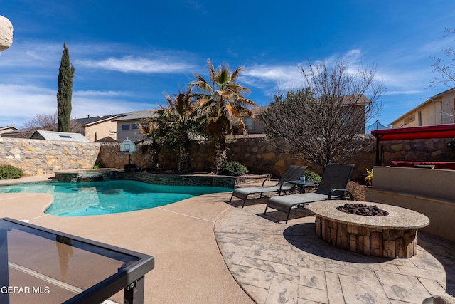 view of pool featuring an outdoor fire pit, a pool with connected hot tub, a fenced backyard, and a patio