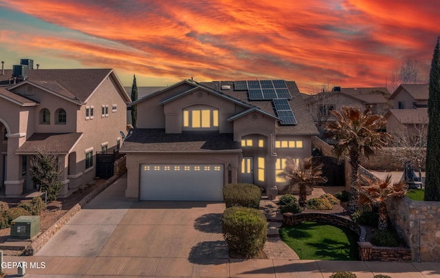 3612 Tierra Calida Dr, El Paso, TX 79938 - view of front of home with a garage, a shingled roof, concrete driveway, cooling unit, and roof mounted solar panels