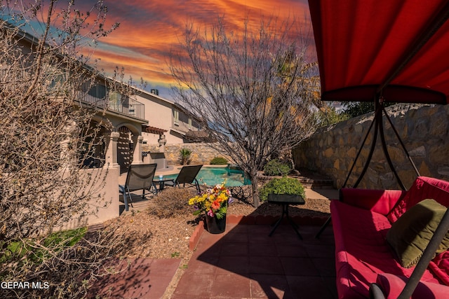 3612 Tierra Calida Dr, El Paso, TX 79938 - patio terrace at dusk with a balcony, fence, and a fenced in pool
