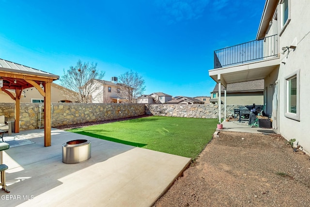 view of yard featuring a balcony, a patio area, a fenced backyard, and a gazebo