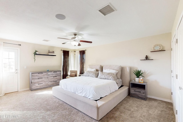 bedroom featuring baseboards, multiple windows, visible vents, and light colored carpet