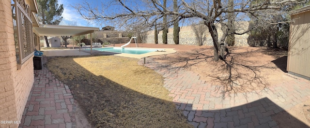 view of swimming pool featuring a fenced in pool, a water slide, and a patio area