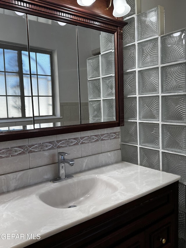 bathroom featuring vanity and decorative backsplash