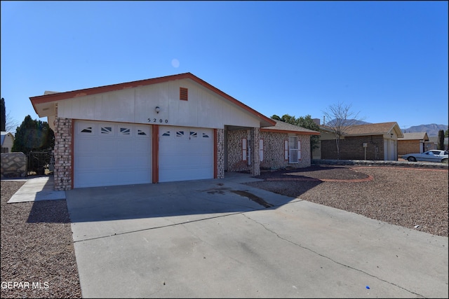 ranch-style house with driveway, brick siding, and an attached garage