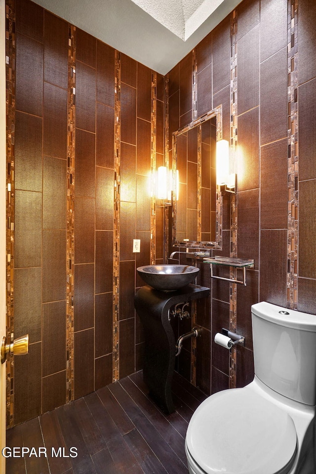 425 Golden Springs Dr, El Paso, TX 79912 - half bathroom featuring toilet, vanity, and tile walls