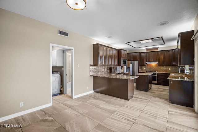 425 Golden Springs Dr, El Paso, TX 79912 - kitchen with dark brown cabinetry, a sink, visible vents, decorative backsplash, and washer / clothes dryer