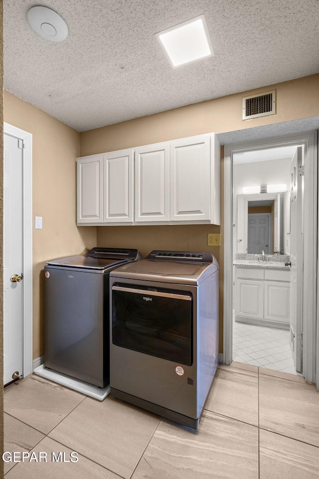 425 Golden Springs Dr, El Paso, TX 79912 - laundry room with cabinet space, visible vents, a sink, a textured ceiling, and separate washer and dryer